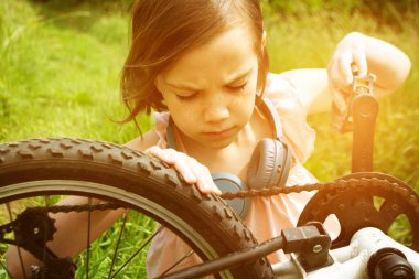 Beyaz elbiseli sarışın bir kadın güzel süslü çiçek sepetiyle bisiklete biner ve mutludur. Yüksek kalite fotoğraf