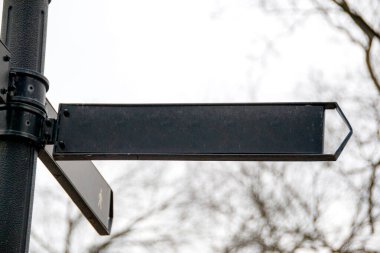 Mavi gökyüzüne karşı yazılmış işaretleri imzalayın. Mavi gökyüzü arka planında siyah yön işaretleri. Yüksek kalite fotoğraf