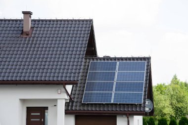 Çatıya Güneş Hücresi yerleştirmek. Çatıdaki güneş panelleri. Çatı ve duvarında modern güneş panelleri olan tarihi çiftlik evi. Yüksek kalite fotoğraf