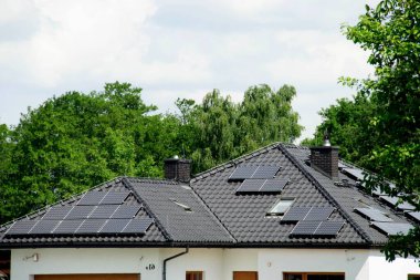 Çatıya Güneş Hücresi yerleştirmek. Çatıdaki güneş panelleri. Çatı ve duvarında modern güneş panelleri olan tarihi çiftlik evi. Yüksek kalite fotoğraf