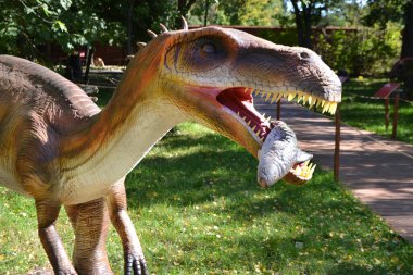 Dino Park 'taki hadrosaurus, çocuk savaş sahnesi için Dino Parkı' ndaki baş Parasaurolophus dinozorunu kapatır. Dinozor, güneşli bir yaz gününde ağaçların arasında ormanda duruyor. Yüksek kalite fotoğraf