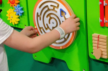 Çocuk Montessori oyunu oynuyor. Çocuk tahta oyuncak ayırıcı topluyor. Çok renkli geometrik şekiller, daire, kare, üçgen, dikdörtgen. Erken çocukluk gelişimi. Yüksek kalite fotoğraf