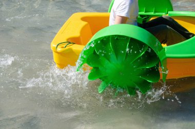 Çocuk su kayığı oynuyor. Yumuşak odaklanma. Küçük bir kız, tatil köyündeki bir havuzda renkli bir tekneye biniyor. Yüksek kalite fotoğraf. 