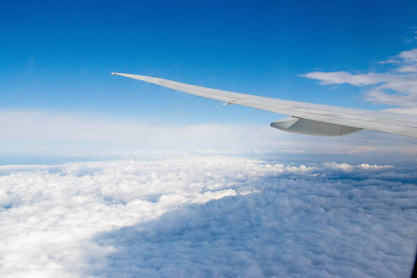 White passenger airplane flying in the sky amazing clouds in the background - Travel by air transport. High quality photo