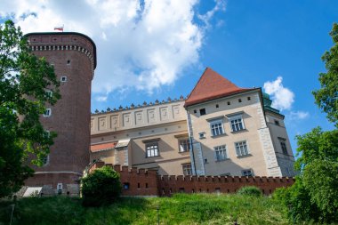 The view of the Wawel Royal Castle from the ground. Fortress wall, Wawel Danish tower, representative royal chambers. Ancient facade of the building Wawel Castle City of Krakow. High quality photo clipart