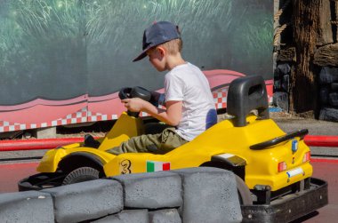 Bir çocuk oyun sahasında go-kart araba kullanıyor. Go kart popüler bir motor sporudur. Yüksek kalite fotoğraf