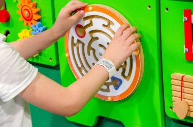 Çocuk Montessori oyunu oynuyor. Çocuk tahta oyuncak ayırıcı topluyor. Çok renkli geometrik şekiller, daire, kare, üçgen, dikdörtgen. Erken çocukluk gelişimi. Yüksek kalite fotoğraf