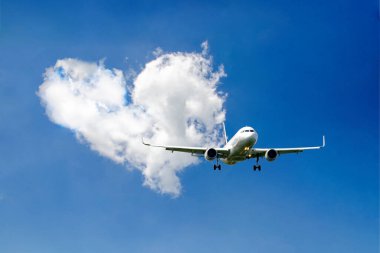 White passenger airplane flying in the sky amazing clouds in the background - Travel by air transport. High quality photo clipart