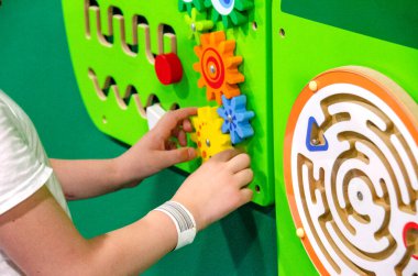 Çocuk Montessori oyunu oynuyor. Çocuk tahta oyuncak ayırıcı topluyor. Çok renkli geometrik şekiller, daire, kare, üçgen, dikdörtgen. Erken çocukluk gelişimi. Yüksek kalite fotoğraf