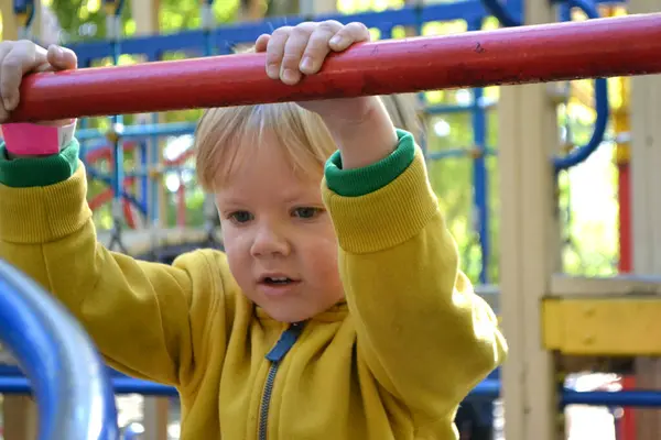 stock image Blond haired boy has fun at playground in local park. High quality photo