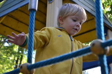 Küçük çocuklar etrafta koşuşturup oyun bahçesinde oynuyorlar. Küçük bir çocuk için oyun merkezi. Küçük kız dışarıda oynuyor. Yaz çocukları eğlencesi konsepti. Yüksek kalite fotoğraf