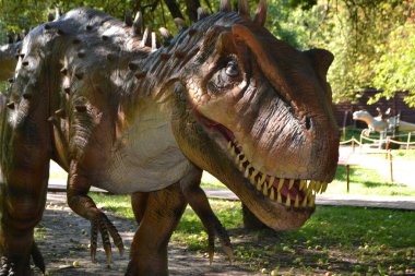 Dino Park 'taki hadrosaurus, çocuk savaş sahnesi için Dino Parkı' ndaki baş Parasaurolophus dinozorunu kapatır. Dinozor, güneşli bir yaz gününde ağaçların arasında ormanda duruyor. Yüksek kalite fotoğraf