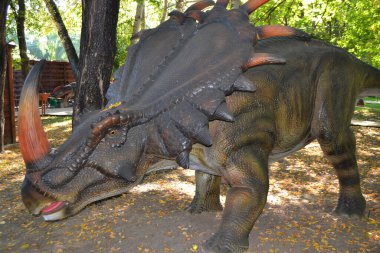 Dino Park 'taki hadrosaurus, çocuk savaş sahnesi için Dino Parkı' ndaki baş Parasaurolophus dinozorunu kapatır. Dinozor, güneşli bir yaz gününde ağaçların arasında ormanda duruyor. Yüksek kalite fotoğraf