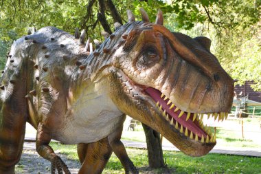 Dino Park 'taki hadrosaurus, çocuk savaş sahnesi için Dino Parkı' ndaki baş Parasaurolophus dinozorunu kapatır. Dinozor, güneşli bir yaz gününde ağaçların arasında ormanda duruyor. Yüksek kalite fotoğraf