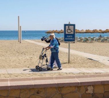 Torremolinos, Endülüs, İspanya sahillerinde yürüyen yaşlı çift.