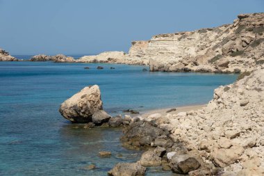 Rocky beach at the Mediterranean Sea at Lefkos on the western part of the island of Karpathos, Greece. clipart