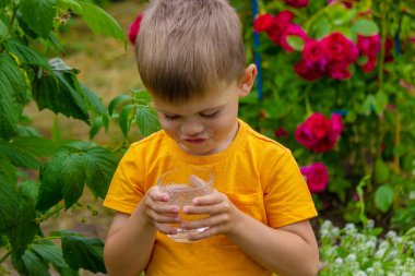 Çocuk yazın temiz su içer. Seçici odak.