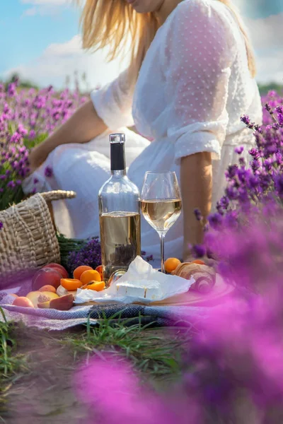 柳条篮 配上美味的食物 在薰衣草地里参加浪漫的野餐 那女孩倒酒 有选择的重点 — 图库照片
