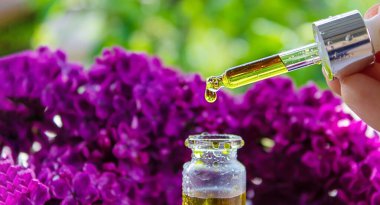 Şırınga leylağı, temel yağ. Bir şişe leylak çiçekli güzellik yağı. seçici odak