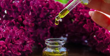 Şırınga leylağı, temel yağ. Bir şişe leylak çiçekli güzellik yağı. seçici odak