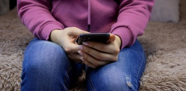 Kız telefonu elinde tutuyordu. Seçici odak