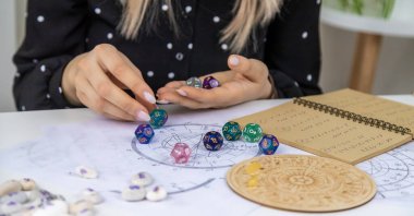 Woman numerologist astrologer counts numbers. Selective focus. People.