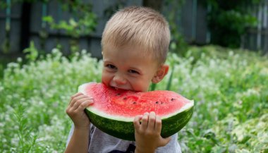 A child eats a watermelon. Selective focus. Nature