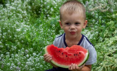 A child eats a watermelon. Selective focus. Nature