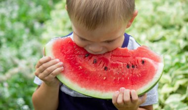 A child eats a watermelon. Selective focus. Nature