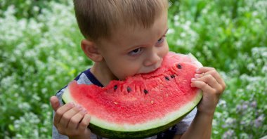 A child eats a watermelon. Selective focus. Nature