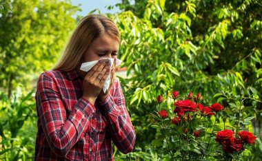 A young woman is allergic to flowers. Selective focus