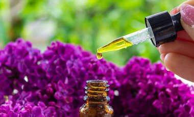 Şırınga leylağı, temel yağ. Bir şişe leylak çiçekli güzellik yağı. seçici odak