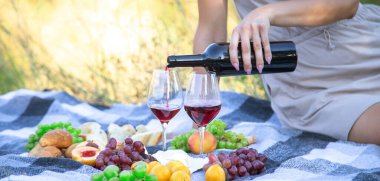 picnic in nature, girl pouring wine, couple in love. nature. selective focus