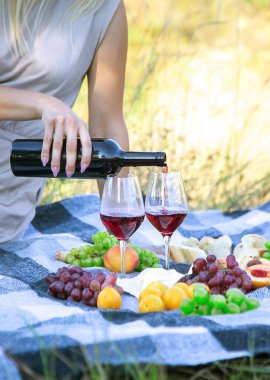 picnic in nature, girl pouring wine, couple in love. nature. selective focus