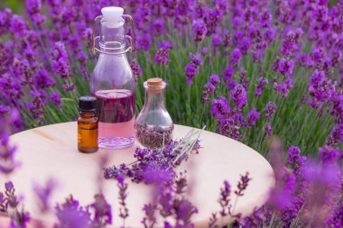 Lavanta yağlı kavanozlar, lavanta çiçekleri, lavanta tarlasının arka planında. Seçici odak