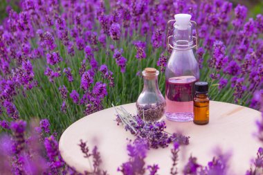 Lavanta yağlı kavanozlar, lavanta çiçekleri, lavanta tarlasının arka planında. Seçici odak