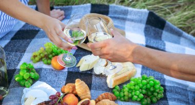 Aşıklar piknikte beyaz şarap içer. Seçici odaklanma. Doğa