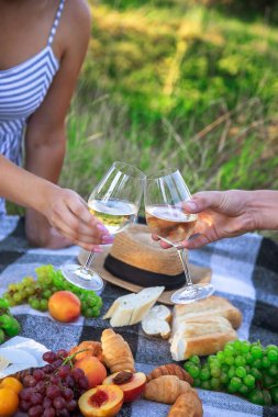Aşıklar piknikte beyaz şarap içer. Seçici odaklanma. Doğa