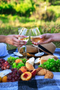 Aşıklar piknikte beyaz şarap içer. Seçici odaklanma. Doğa