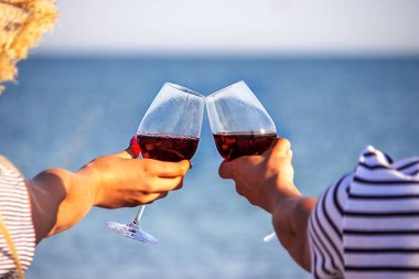 Deniz kenarında şarap içen romantik bir çift. Seçici odak