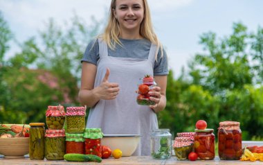A woman preserves vegetables in jars. Selective focus. Food.
