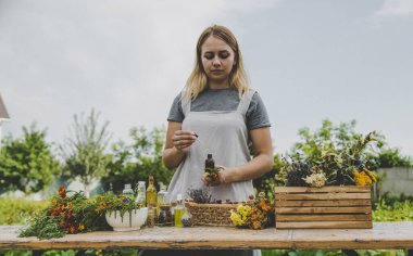 Woman with medicinal herbs and tinctures. Selective focus. Nature.