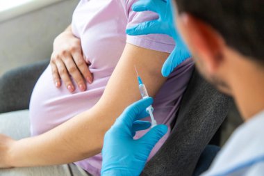 Hamile bir kadın aşı yapar. Seçici odaklanma. Doktor.