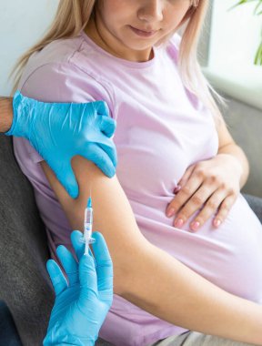 Hamile bir kadın aşı yapar. Seçici odaklanma. Doktor.