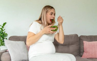 Hamile bir kadın sebzeli salata yer. Seçici odaklanma. Yiyecek..