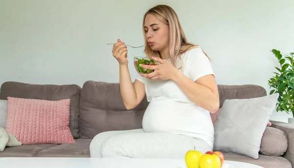 stock image A pregnant woman eats a salad with vegetables. Selective focus. Food.