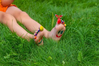 a smile painted with paints on the child's arms and legs. Selective focus