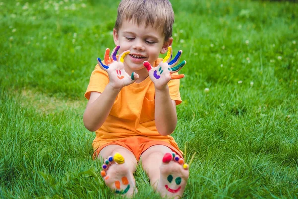 孩子的手在夏天的五彩缤纷中 一个微笑在男孩的手掌上 有选择的重点 — 图库照片