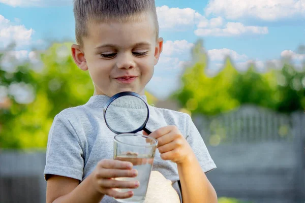 Uma Criança Olha Para Água Através Uma Lupa Foco Seletivo — Fotografia de Stock