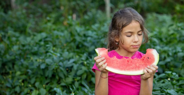 A child eats a watermelon. Selective focus. Nature